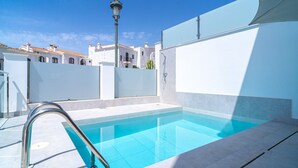 A swimming pool with a metal ladder, surrounded by white walls and a clear blue sky. - Villa Casa Mezcal by Casasol (Nerja)