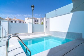 A swimming pool with a metal ladder, surrounded by white walls and a clear blue sky. - Villa Casa Mezcal by Casasol (Nerja)