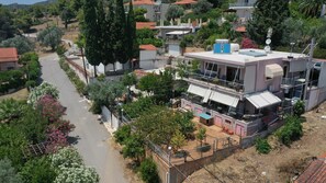 Ein Wohngebäude mit Balkon, Solaranlage und einem durch eine Hecke umgebenen Garten.