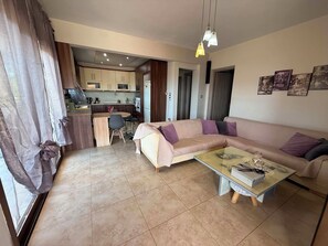 Ein Wohnzimmer mit einer Couch, einem Couchtisch und einem Essbereich mit Stühlen.