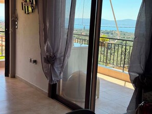 Ein Balkon mit Blick auf eine hügelige Landschaft, einem Tisch und einem Stuhl.