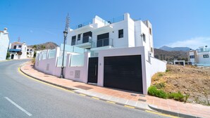 A modern two-story building with a garage, a street in front, and a clear sky. - Villa Casa Mezcal by Casasol (Nerja)