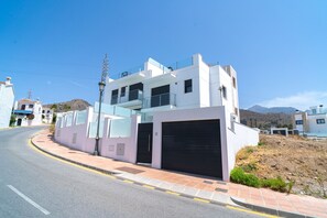 A modern two-story building with a garage, a street in front, and a clear sky. - Villa Casa Mezcal by Casasol (Nerja)