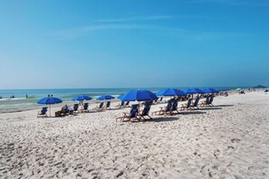 A beach with rows of blue umbrellas and beach chairs. - Summit 908/908A Luxury Gulf-View Escape | TOPS'L Resort | Walk to the Beach (Miramar Beach)