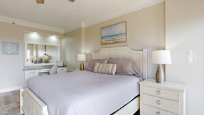A bedroom with a large bed, bedside tables, a dresser, a mirror, and a painting of a beach scene. - Summit 0908A Romantic Gulf-View Studio at TOPS'L Resort (Miramar Beach)
