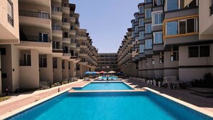 Un hotel con piscina central rodeada de balcones.