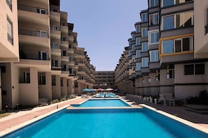 Ein Hotel mit einem zentral gelegenen Schwimmbad, umgeben von Balkonen.