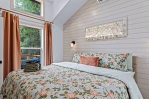 A bedroom with a bed, curtains, a window, and a wall-mounted light fixture. - Tiny Home, HUGE Views, Massive Deck + Fire pit (Blairsville)