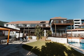 A hotel with a pool, outdoor seating, and a covered patio area. - One Bed Apt Modern Cozy Secure Sea Point (Cape Town)