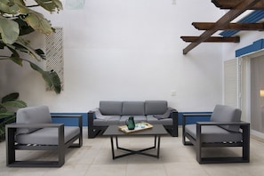 A modern outdoor seating area with a grey sofa, two armchairs, and a coffee table. - Beautiful 2-Bedroom Apartment with Private Pool and Garden in Quinta do Lago (Faro)