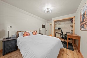 A bedroom with a bed, bedside tables, a desk, and a chair. - Riverfront Log Home - 28 Acres - Fire Pit (Warner)