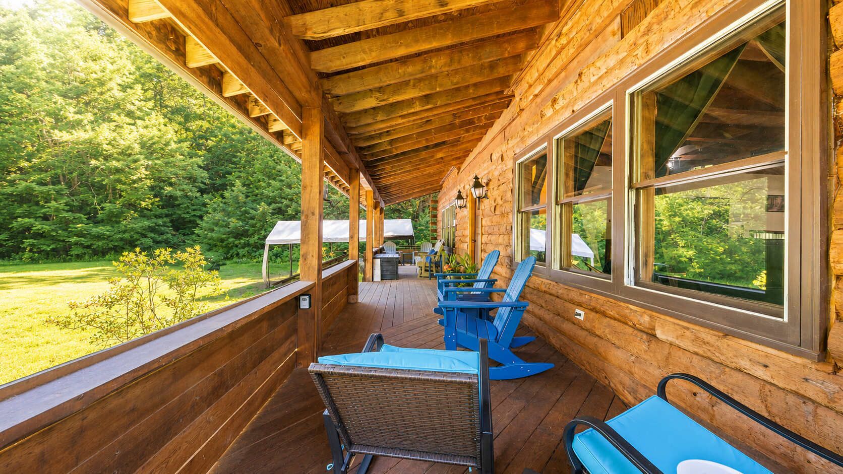 Terraza de madera con asientos exteriores y vista a un paisaje verde.