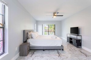 A bedroom with a bed, a TV stand, and a ceiling fan. - Hernando Beach 3BR - Water Views, Fireplace (Hernando Beach)