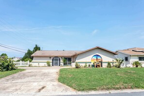 A two-story house with a front entrance, a driveway, and a well-maintained lawn. - Hernando Beach 3BR - Water Views, Fireplace (Hernando Beach)