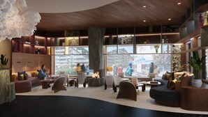 Un área de estar moderna con asientos, chimenea y ventanas amplias que ofrecen vistas de la ciudad.
