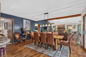 Un coin repas avec une table et des chaises en bois, un tapis et une cheminée.