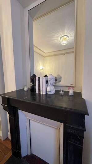 A black vanity with a large mirror, a white bust sculpture, and a small candle on the counter. - Place du Trocadéro (5-minute walk) - Elegant 3-room apartment, 50 m² (max. 6 people) (Paris)