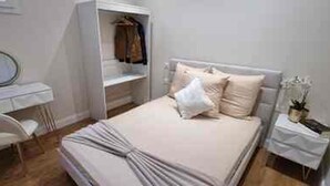 A bedroom with a bed, a bedside table, a chair, a wardrobe, and a mirror. - Place du Trocadéro (5-minute walk) - Elegant 3-room apartment, 50 m² (max. 6 people) (Paris)
