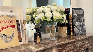 A marble fireplace mantel with a framed picture, a vase with white flowers, and a book titled 'Dossier 40/44'. - Place du Trocadéro (5-minute walk) - Elegant 3-room apartment, 50 m² (max. 6 people) (Paris)