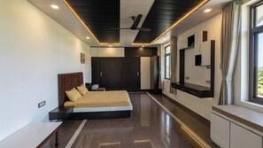 Quarto moderno com cama, ventoinha no teto, armário embutido e janela com cortinas.
