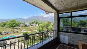 Quarto com varanda com vista para uma paisagem montanhosa.
