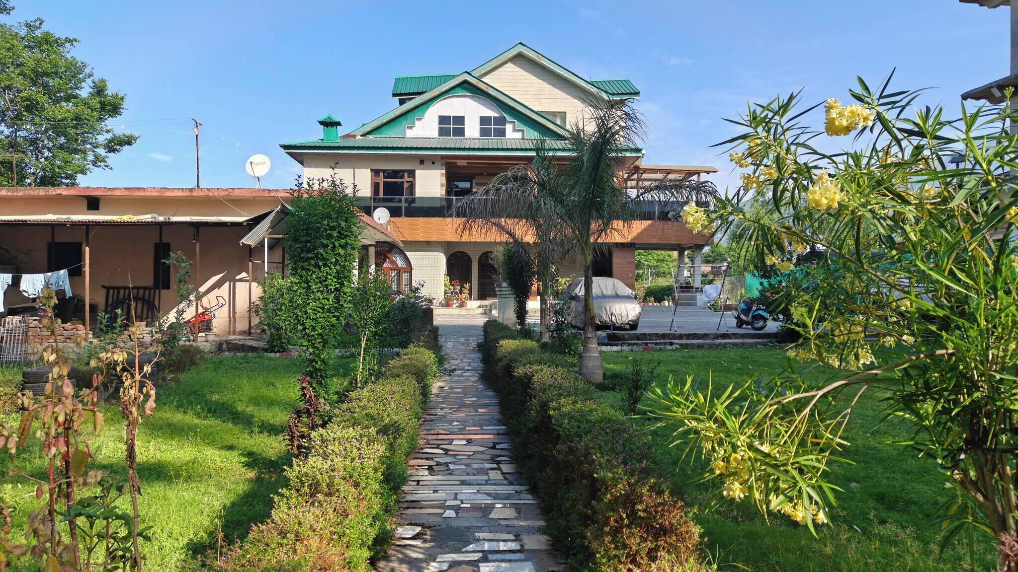 A two-story house with a stone pathway leading to the entrance.