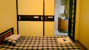 Ein Zimmer mit einem Bett, einem Kleiderschrank und einem durchgegangenen Tür angedeuteten Badezimmer.