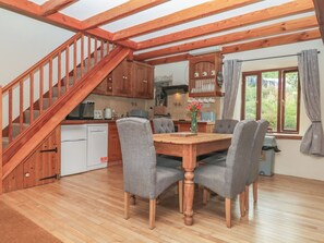 A wooden staircase leading to a dining area with a table and chairs. - Brimble Cottage at Dockwell Farm (Newton Abbot)