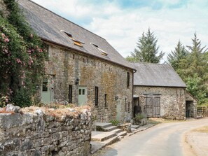 A rustic stone building with a sloped roof, a small porch, and a wooden door. - Brimble Cottage at Dockwell Farm (Newton Abbot)