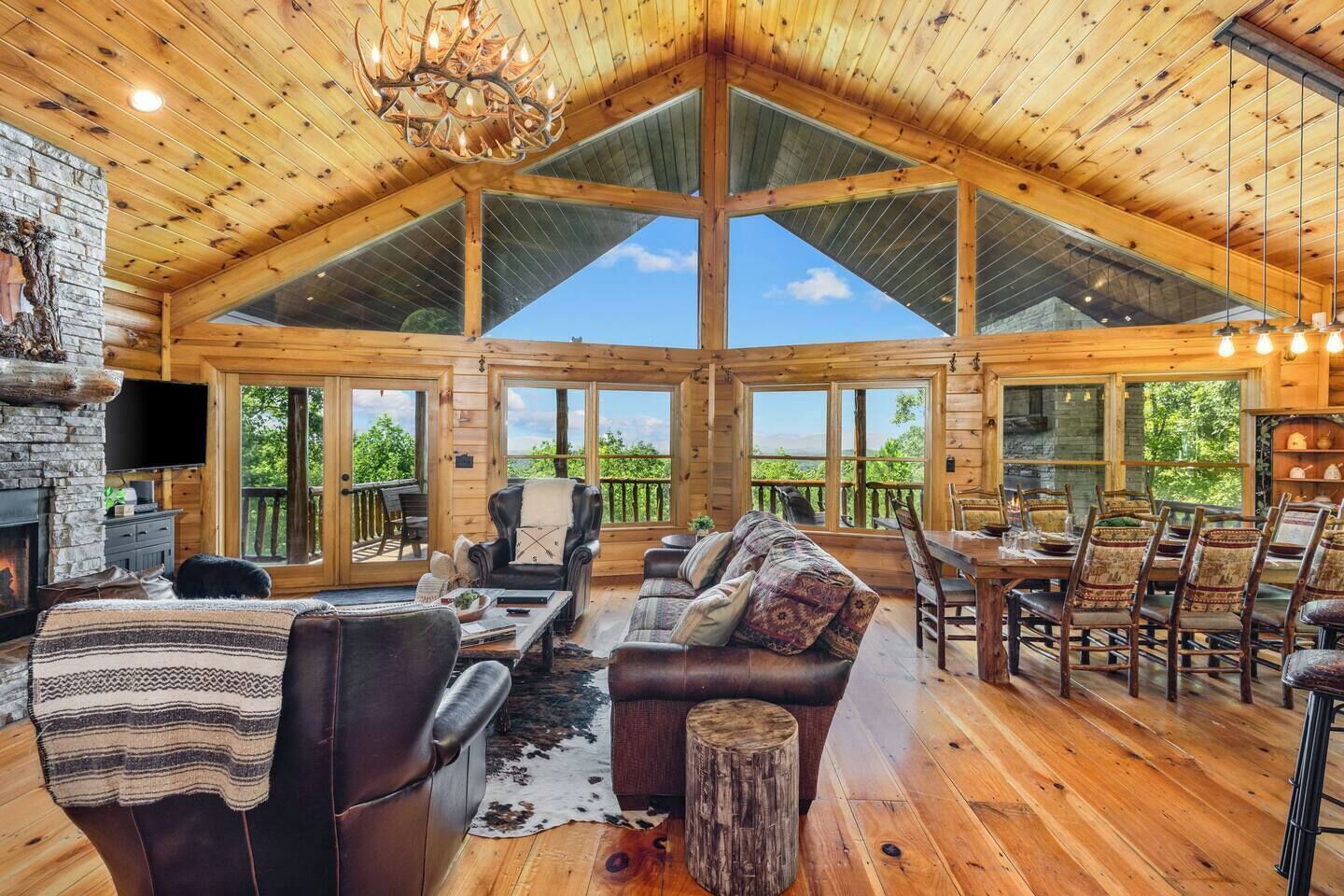 Un intérieur spacieux en bois, doté d’une cheminée, de meubles en cuir et d’un coin repas.