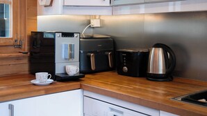 Una cocina moderna con cafetera, tostadora y hervidor sobre la encimera.