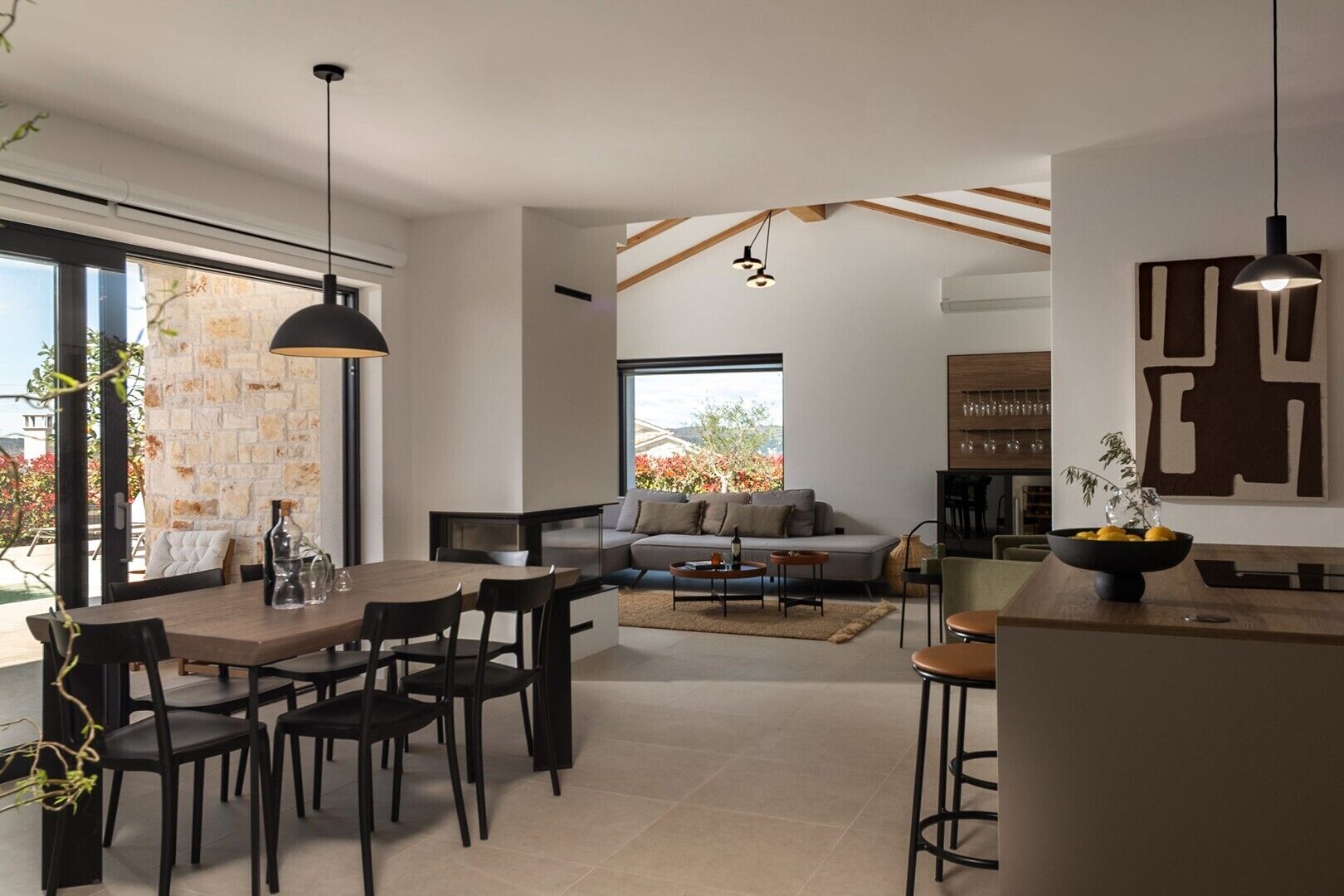 A modern interior with a dining area, a sofa, and a kitchen.