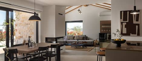 A modern interior with a dining area, a sofa, and a kitchen.