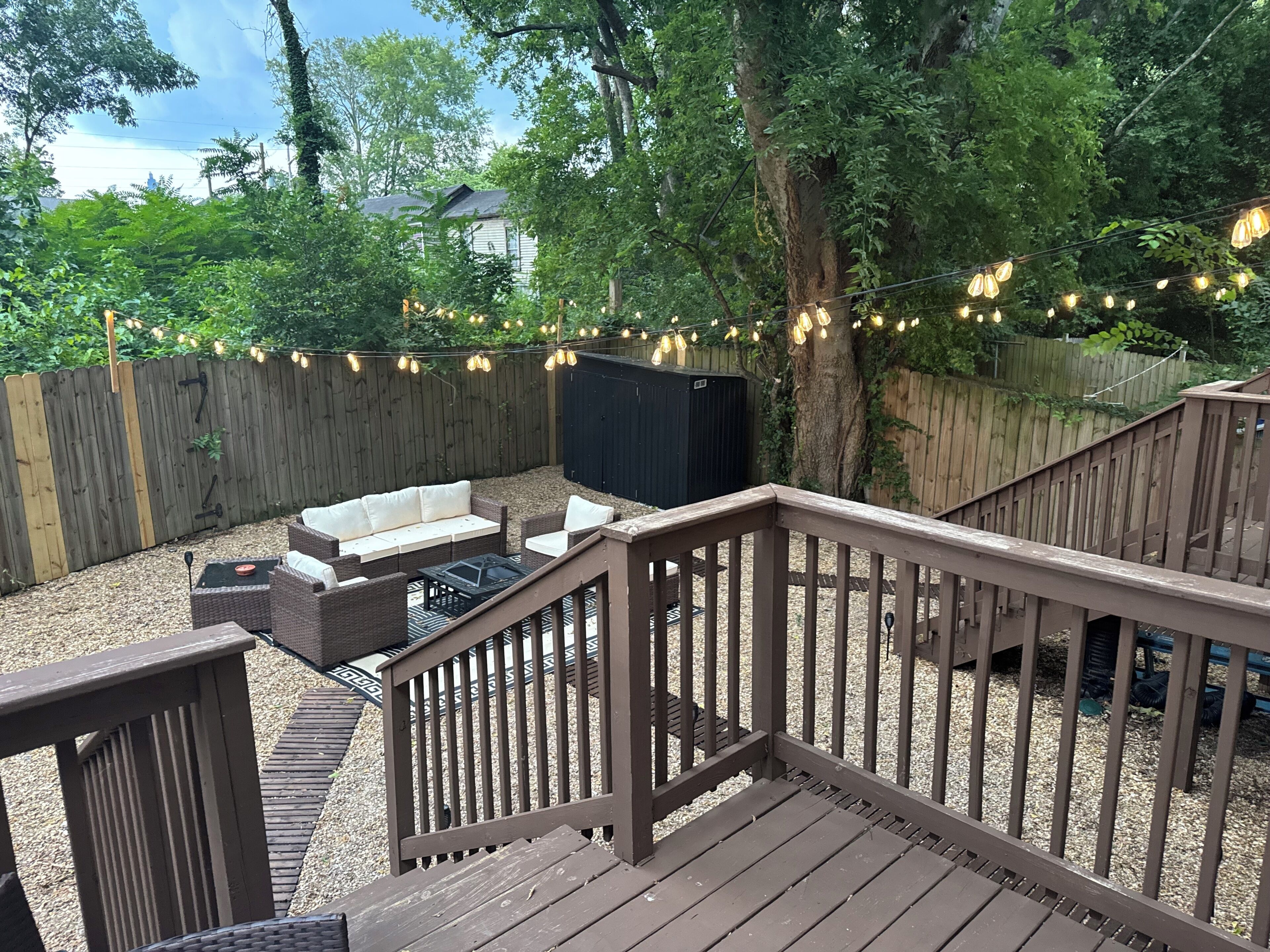 A wooden deck with a built-in seating area, a small table, and a grill.