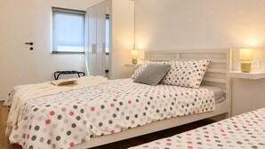 Ein Schlafzimmer mit Bett, Nachttischen, einem Kleiderschrank und einem Fenster.