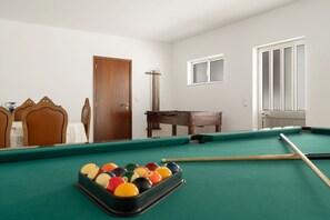 A pool table with balls, a wooden door, a window, and a small table with a cloth. - Vivenda Ribeiro: House with Mountain View, Private Pool and Wi-Fi (Curvos)