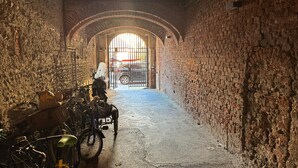 Un estrecho callejón con paredes de piedra y una entrada arqueada.