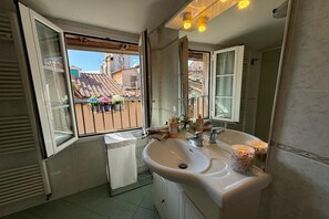 A bathroom with a large window, a sink, and a mirror. - A Bright and Cozy Apartment With Stunning Views in the Heart of Lucca (Lucca)
