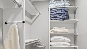 Un vestidor con estantes para ropa doblada, una barra para colgar y un perchero.