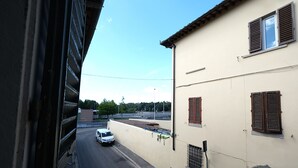 A street view with a building on the right, a white car parked in front, and a pedestrian crossing. - Wine Apartments Florence Soave (Firenze)