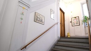 A staircase with a handrail, a door at the bottom, and two framed pictures on the wall. - Wine Apartments Florence Soave (Firenze)