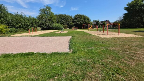 Een speeltuin met diverse speeltoestellen en een heldere lucht.