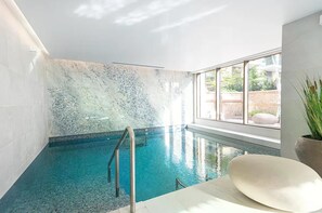 A swimming pool with a glass barrier, a window with a view of greenery, and a potted plant. - Apartment Sleeps 4 - Parking & Wifi (London)