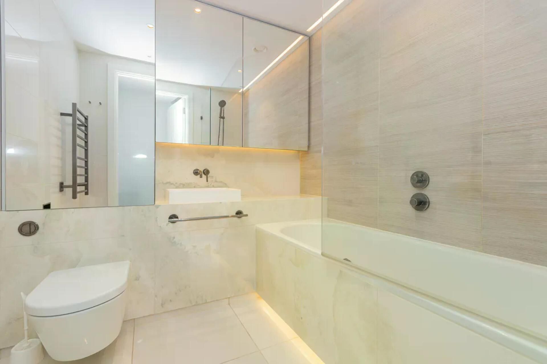 A modern bathroom with a toilet, sink, and bathtub.