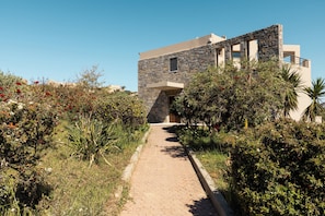 A pathway leading to a building with a stone facade and a flat roof. - Villa Mononaftis (Heraklion)