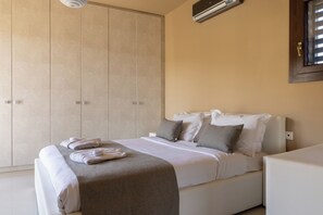 Una habitación de hotel con cama, armario y aire acondicionado.