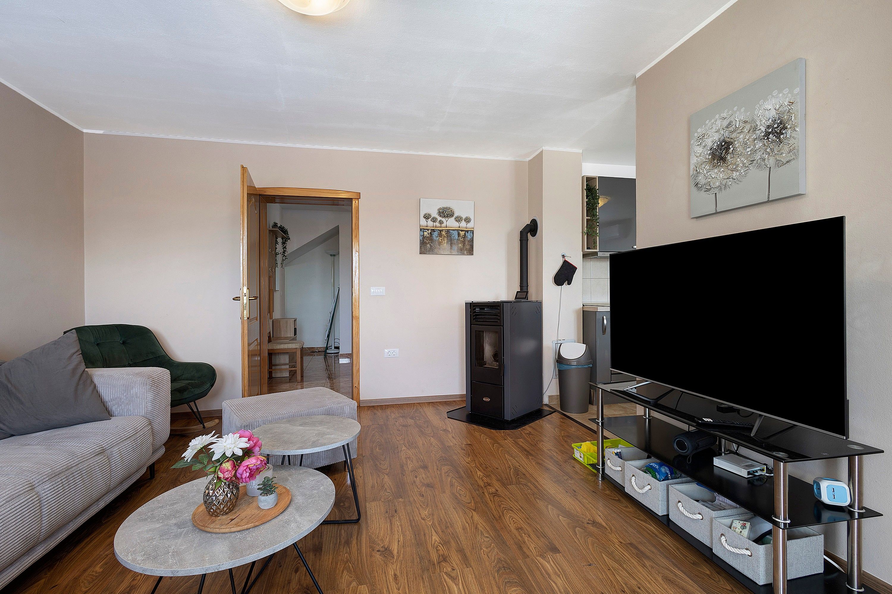 A living room with a sofa, coffee table, and a flat-screen TV on a stand.