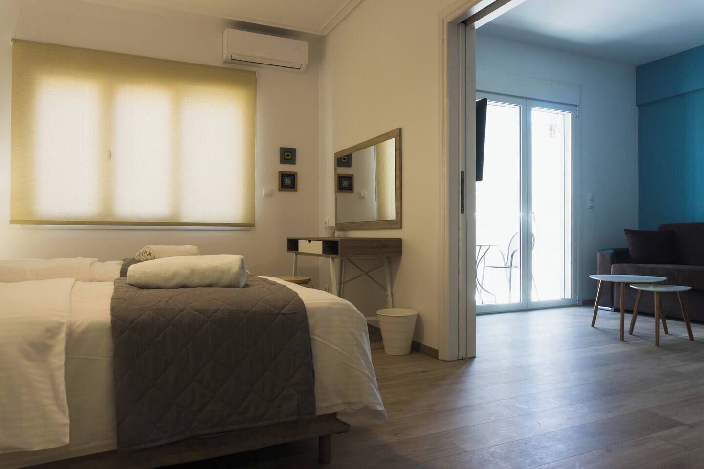 Une chambre d’hôtel avec un lit, un bureau, une chaise, un miroir et une vue sur l’extérieur.