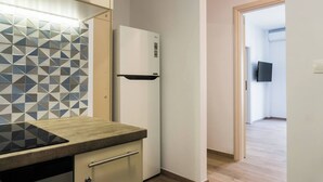 Modernilla designilla varustettu keittiö, jossa on kuvioitu välitila, sisäänrakennettu uuni ja jääkaappi.