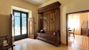A spacious room with a large wooden cabinet, a radiator, and a door leading to another room.